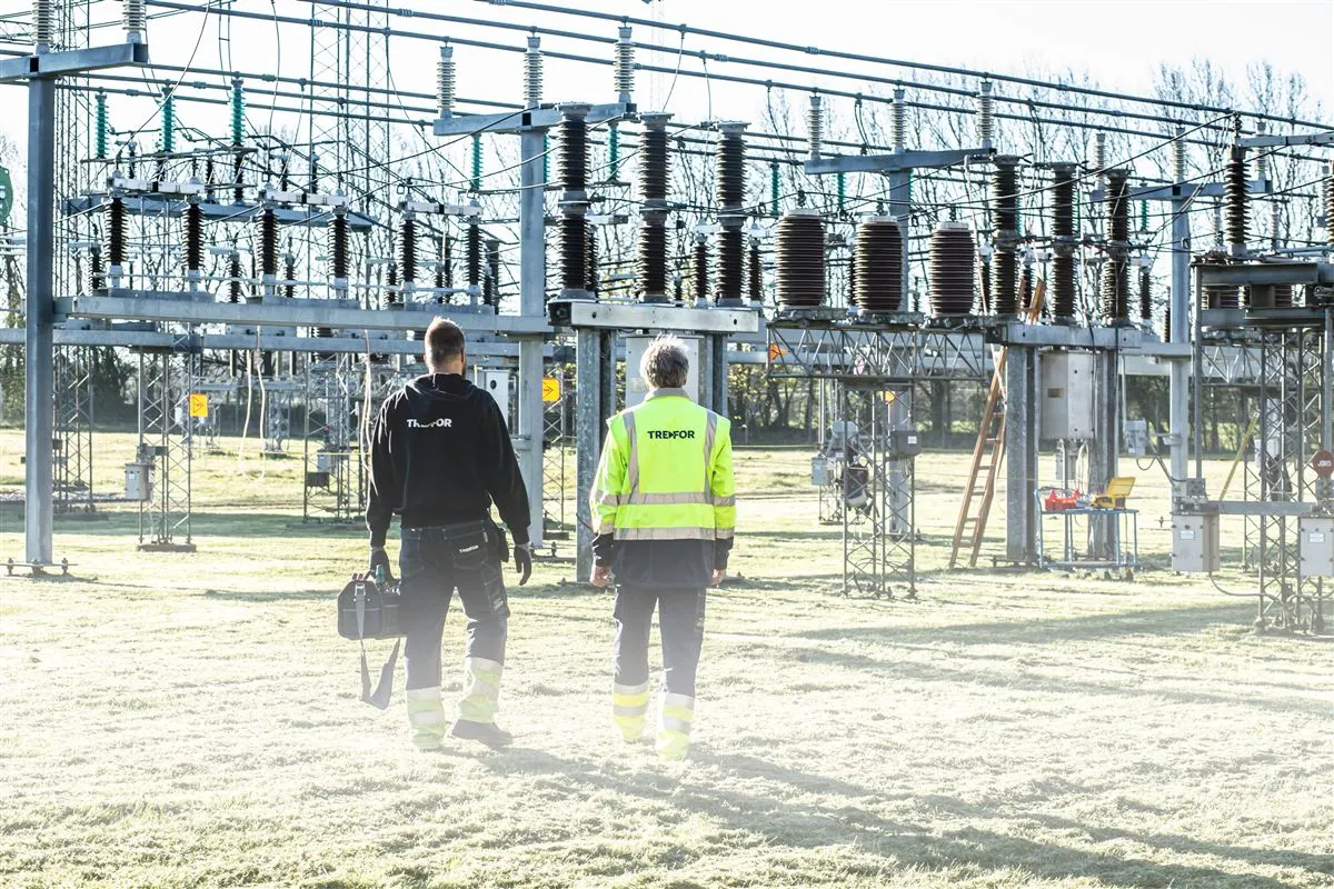 Equipe técnica caminhando em pátio de subestação