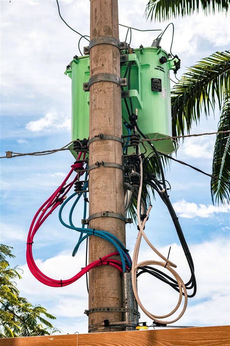 Transformador verde instalado em poste de rede elétrica urbana